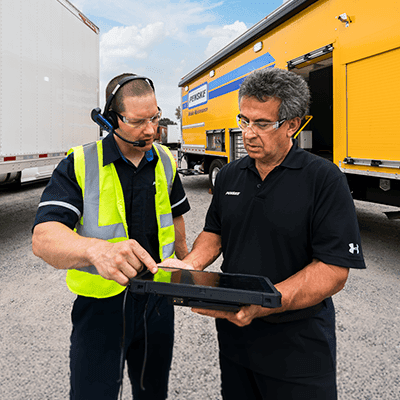 Técnico de mantenimiento y cliente observando una tableta electrónica