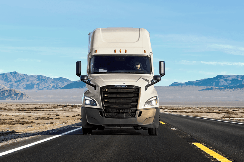 White Penske tractor trailer on a highway in the desert